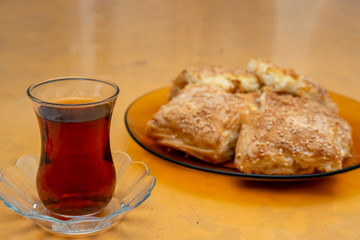 Delicious homemade burrito slices and tea , ready to eat. Turkish borek slices.