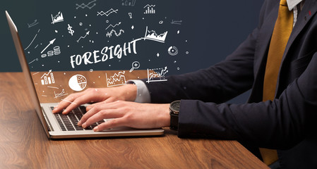 Businessman working on laptop with FORESIGHT inscription, modern business concept