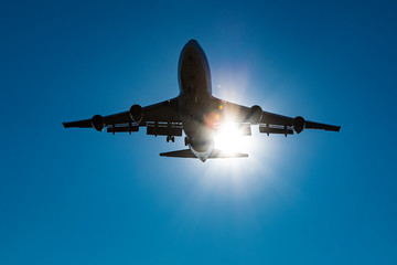 Shape of a Boeing 747 with a sun light leak under a blue sky.