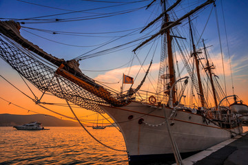 Sailing boats in marina at sunset.