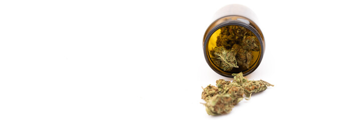 Cannabis ad horizontal banner template. Front shot of brown glass jar full of perfect green dried cannabis buds and several marijuana buds in front of it isolated on white background.