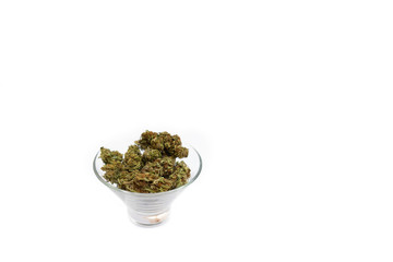 Glass bowl full of perfect green dried cannabis buds isolated on white background. Marijuna buds in glass bowl.