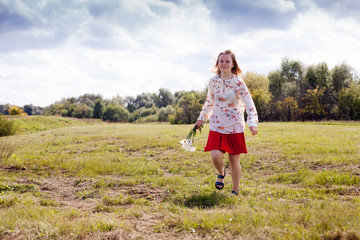 girl  on  field with   bouquet of chamomiles