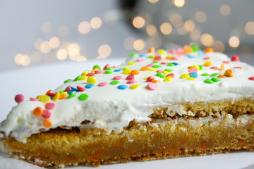 cream cake with colored powder, on a blurred background
