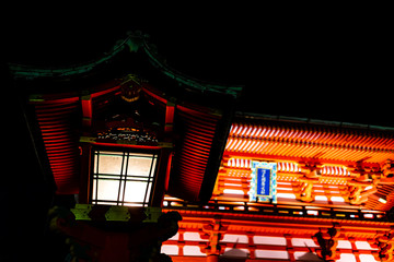 Kyoto, Japan Fushimi Inari shrine building entrance red color in garden park at night with black background and illuminated lantern