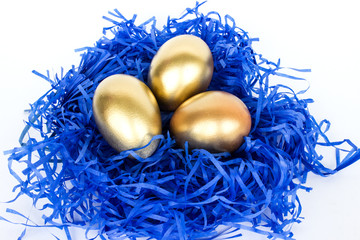 Golden easter eggs in a nest on a white background. Decorative easter decorations. Easter card. Close-up. Flat layout. - 335658834