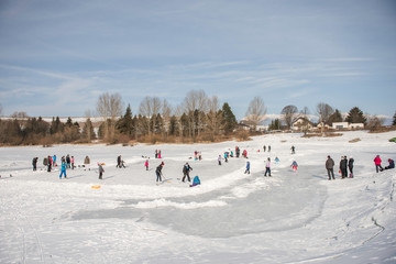 one town community playing ice hockey, skating, enjoying snow on frozen solid ice lake in slovakia 