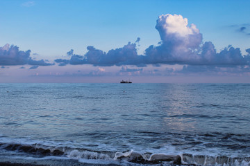 Ship in the evening sea under beautiful clouds