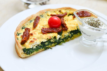 quiche with spinach with herbs and sluggish tomatoes and a creamy sauce