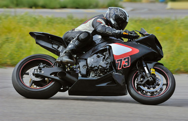 Motorcycle practice leaning into a fast corner on track