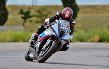 Motorcycle practice leaning into a fast corner on track