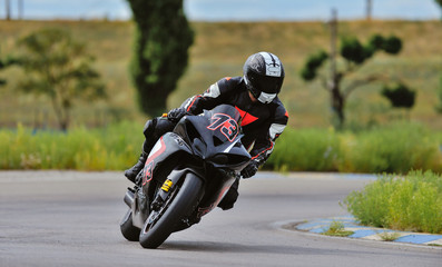 Motorcycle practice leaning into a fast corner on track