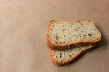 Homemade rye-wheat yeast-free bread made from live sourdough. Two slices of rye-wheat bread with flax and sunflower seeds close-up on a beige linen tablecloth from Kopi space