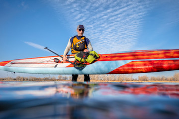 senior male with stand up paddleboard