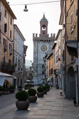 Typical street in Brescia Old Town with Torre della Palata on background, Lombardy, Italy.