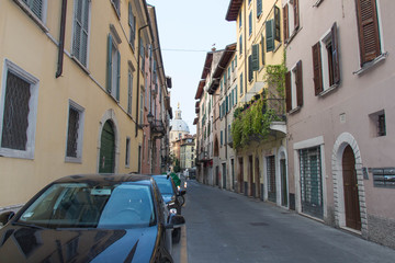 Narrow street with Saint Mary of the Peace Church on background, Brescia Old Town, Lombardy, Italy.