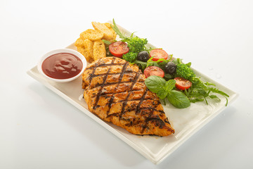 Italian style marinated chicken breast with fresh salads and tomato catchup on a white rectangle plate