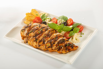 Italian style marinated chicken breast with fresh salads and tomato catchup on a white rectangle plate