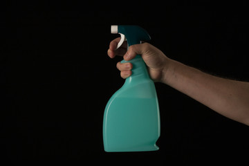 a hand holds a cleaning spray against the virus