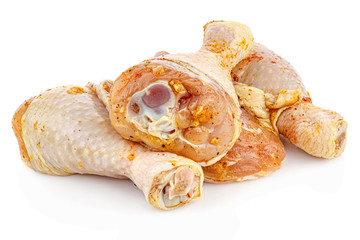 Marinated with spices chicken drumsticks isolated on white background with reflection on glossy surface