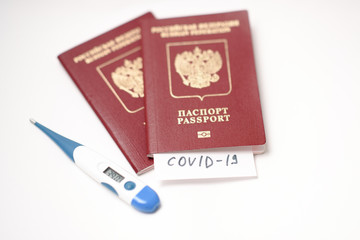 Coronavirus Quarantine and travel concept. Passport with COVID-19 inscription. Coronavirus COVID-19 pandemic. Fever, coronavirus symptoms and travel.