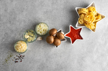 Concept star composition of tagliatelle pasta and vegetarian bolognese recipe on a stone grey...
