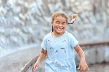 Happy beautiful girl running through the spray of water. © lialia699