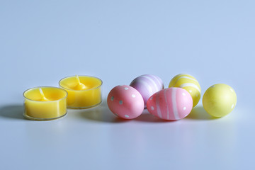 Easter colorful eggs and yellow candles.
