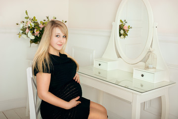 Pregnant girl with a big belly in a studio room