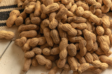 loose and unshelled peanuts in a tablecloth and white wooden table