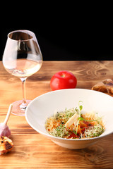 tomato soup with squid and cheese decorated with microgreen on wooden table and white wine