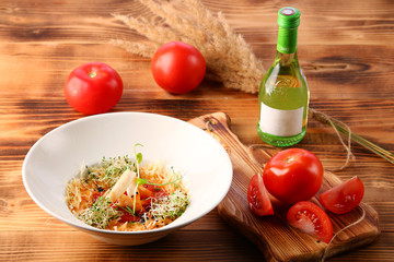 tomato soup with squid and cheese decorated with microgreen on wooden table and white wine