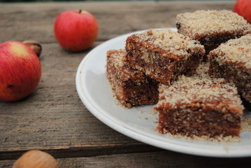 Sweet Homemade Apple Pie Slices, sprinkled with Ground Walnuts, close up view. Wooden background.