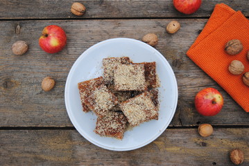 Sweet Homemade Apple Pie, sprinkled with Ground Walnuts, served in a white plate on a wooden retro background. Close up view.
