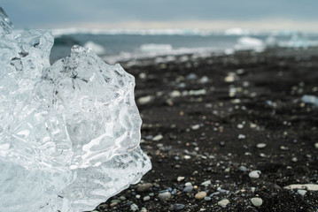 Diamond beach on Iceland or Jokulsarlon Iceberg beach. Crystal ice melting on volcanic beach In...
