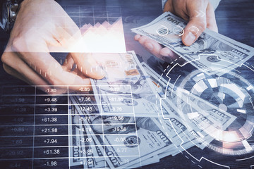 Multi exposure of financial graph drawing hologram and USA dollars bills and man hands. Analysis concept.