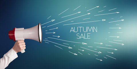 Young girl screaming to megaphone with AUTUMN SALE inscription, shopping concept