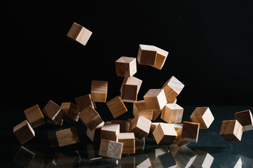 Wooden cubes flying on the black background