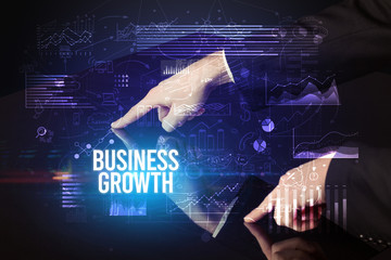 Businessman touching huge screen with BUSINESS GROWTH inscription, cyber business concept