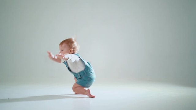 the child is trying to get off his knees on two legs but falls. slow motion