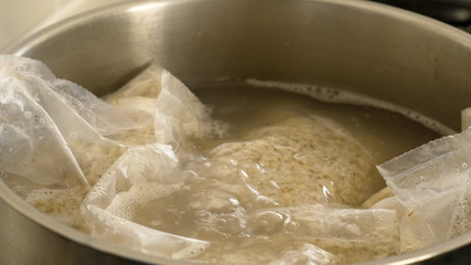 cooking pearl barley porridge in bags on electric cooker