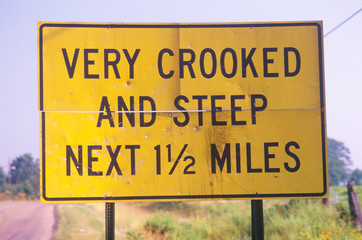 A sign that reads ÒVery crooked and steep next 1 1/2 milesÓ