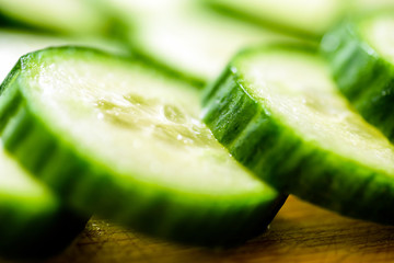 Cucumber cut slices on wooden cutting board