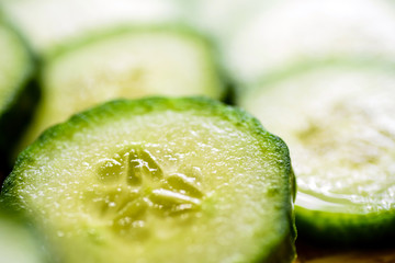 Cucumber cut slices on wooden cutting board