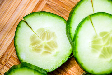 Cucumber cut slices on wooden cutting board