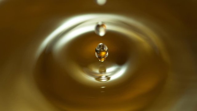 Super Slow Motion Shot of Splashing Oil on Golden Background at 1000fps. Shoot on high speed cinema camera.