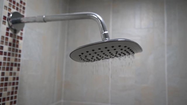 Agua cayendo en c&aacute;mara lenta de una ducha moderna en un lindo ba&ntilde;o