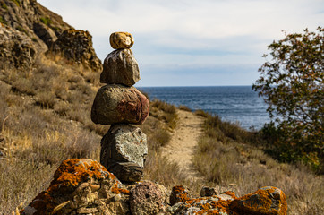 Pyramid of mountain stones in the mountains by the sea