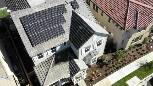 Houses with solar panels on roof in luxury suburb, rising aerial reveal