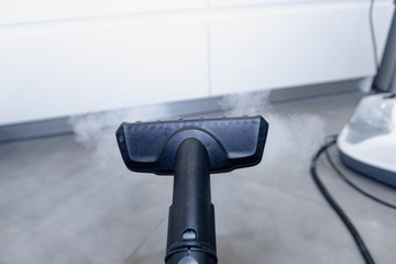 cleaning the floor of the house with a steam cleaner, disinfection of the room.